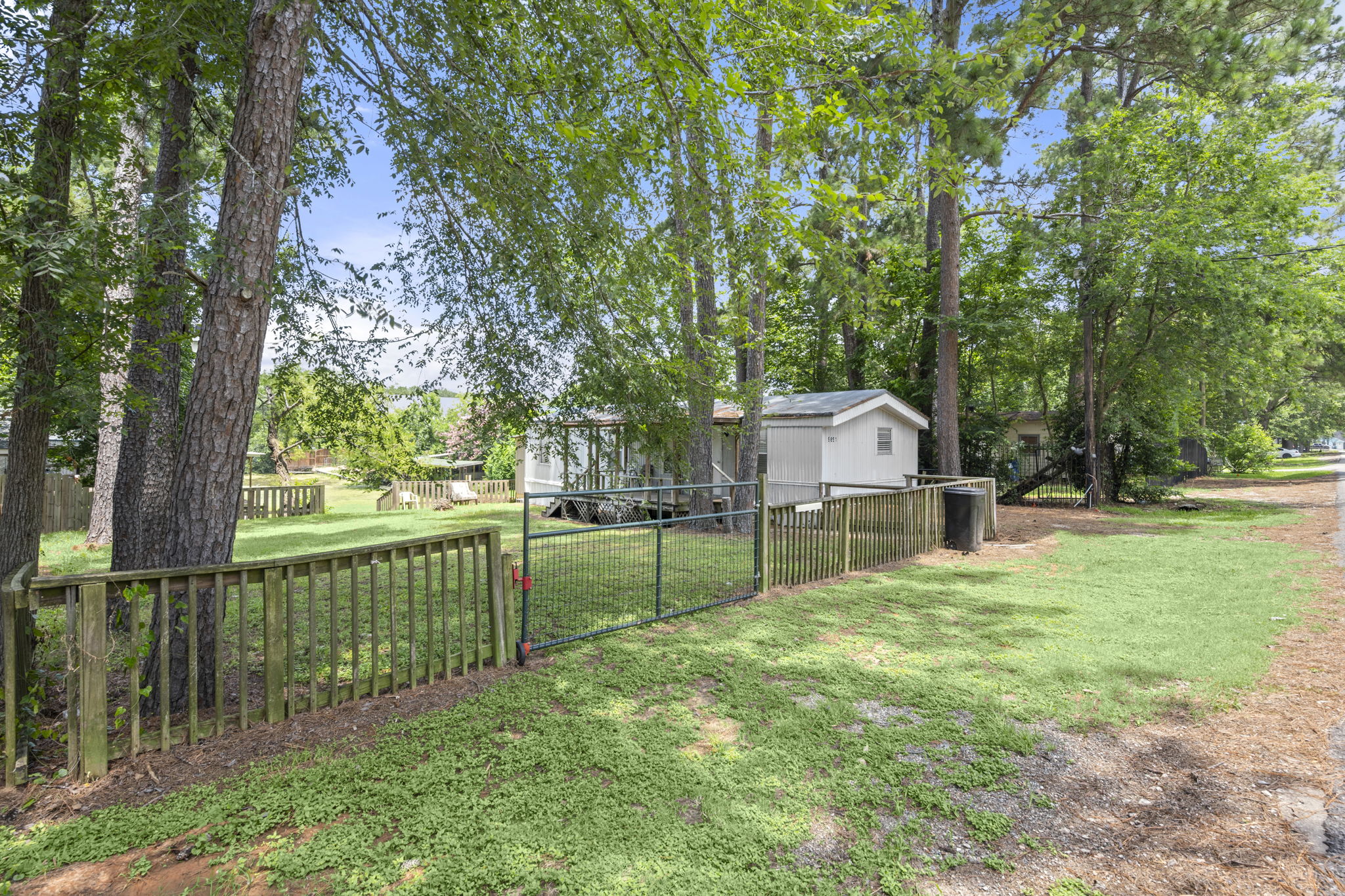 9649 Warm Spring Willis, TX 77318 - Photo 8 of 30 A fully fenced property provides privacy, featuring a storage shed and ample outdoor space.