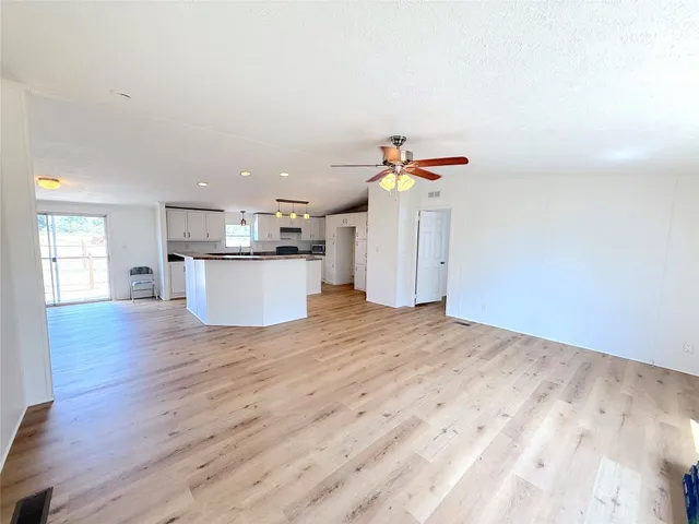 a kitchen with cabinets stainless steel appliances and wooden floor