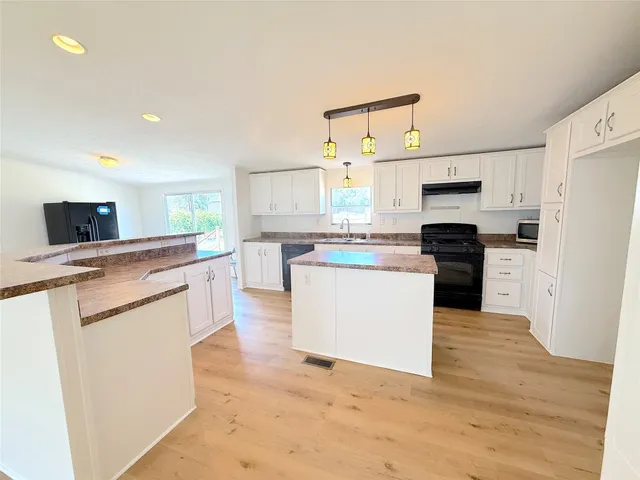 a view of a kitchen with wooden floor and a sink