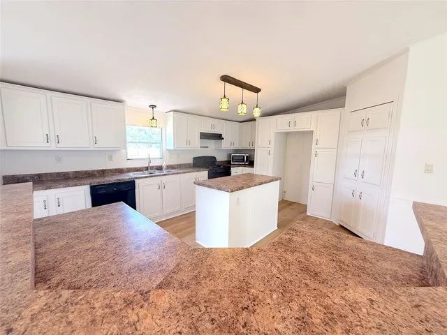 a living room with kitchen island furniture and a kitchen view