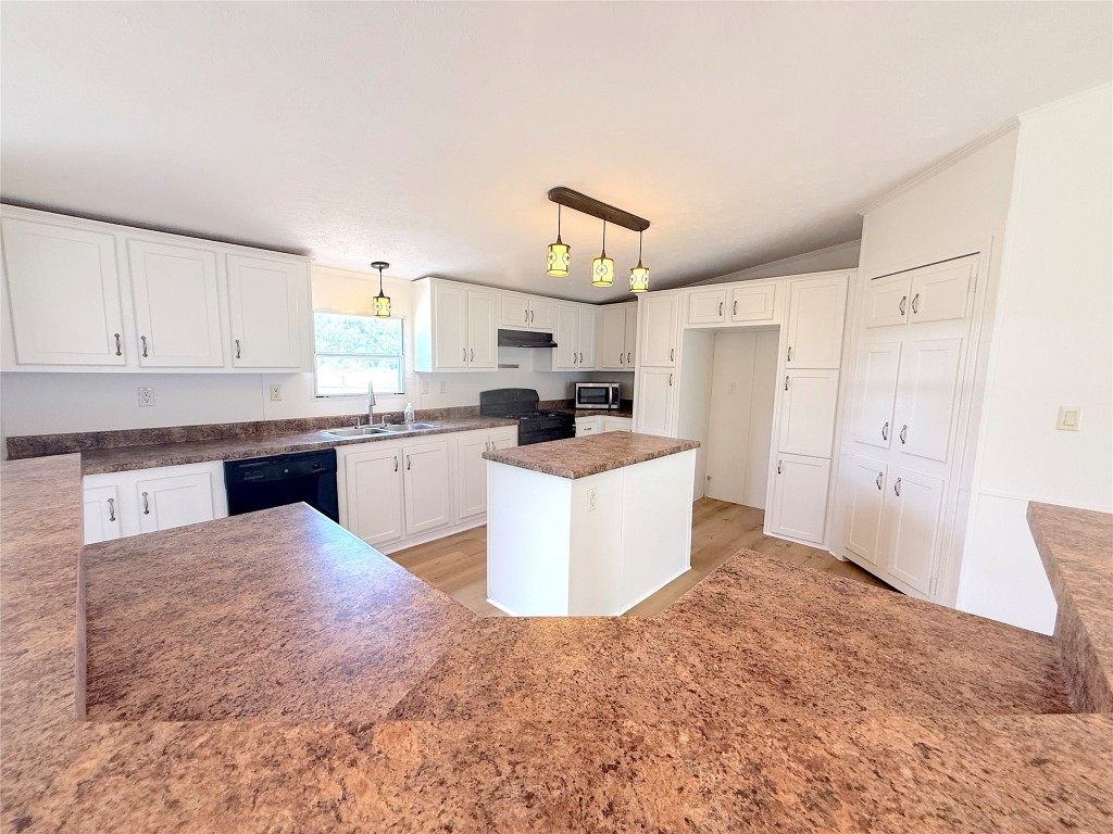 3063 County Road 484 Elgin, TX 78621 - Photo 17 of 29 a kitchen with kitchen island a sink a stove a refrigerator cabinets and a window