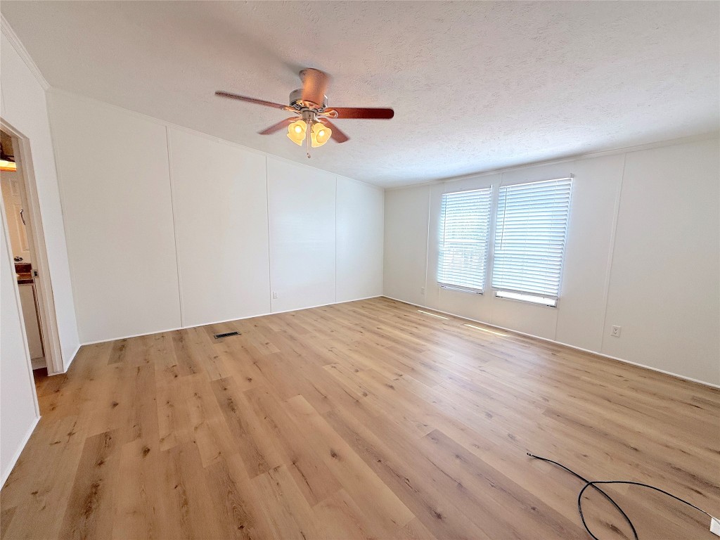 3063 County Road 484 Elgin, TX 78621 - Photo 19 of 29 an empty room with wooden floor fan and windows
