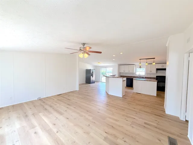 a view of kitchen with kitchen island microwave and cabinets
