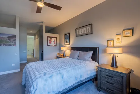 a bedroom with a bed and a lamp on dresser