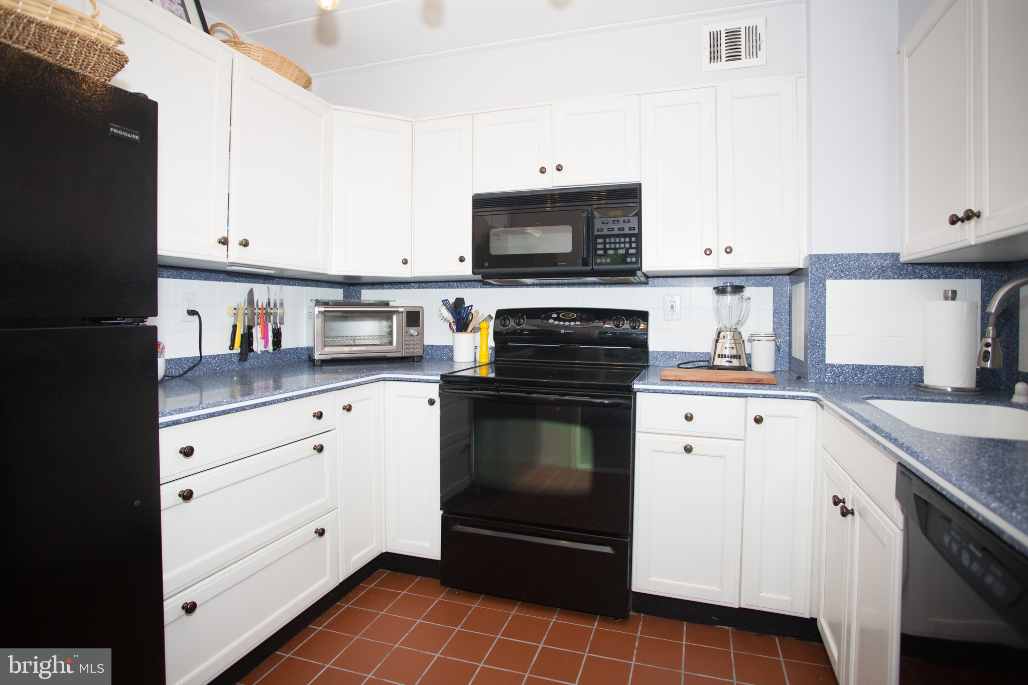 2304 Riddle Avenue, Unit 307 Wilmington, DE 19806 - Photo 10 of 23 a kitchen with white cabinets and black appliances