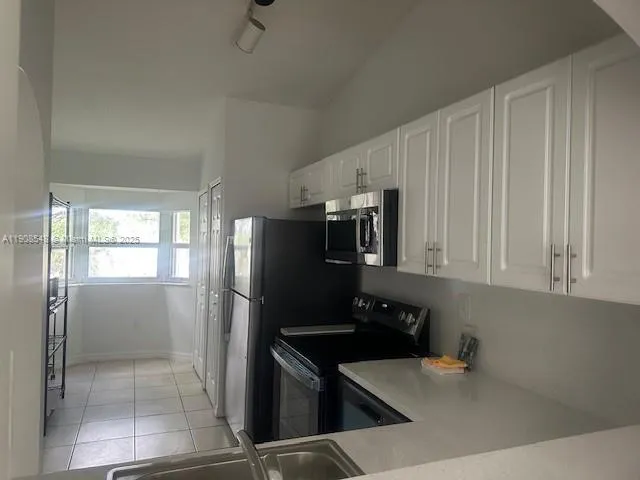 a kitchen with stainless steel appliances a refrigerator and a stove top oven