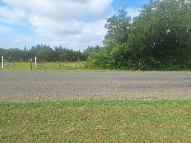 a view of dirt field with trees
