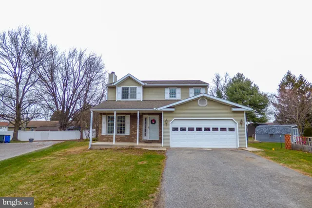 a view of a house with a yard and large tree