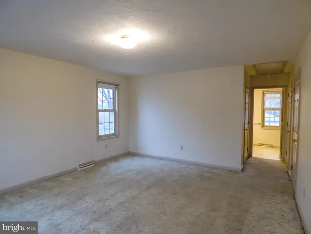 an empty room with windows and closet