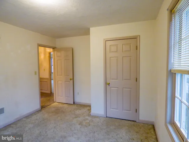 an empty room with windows and closet