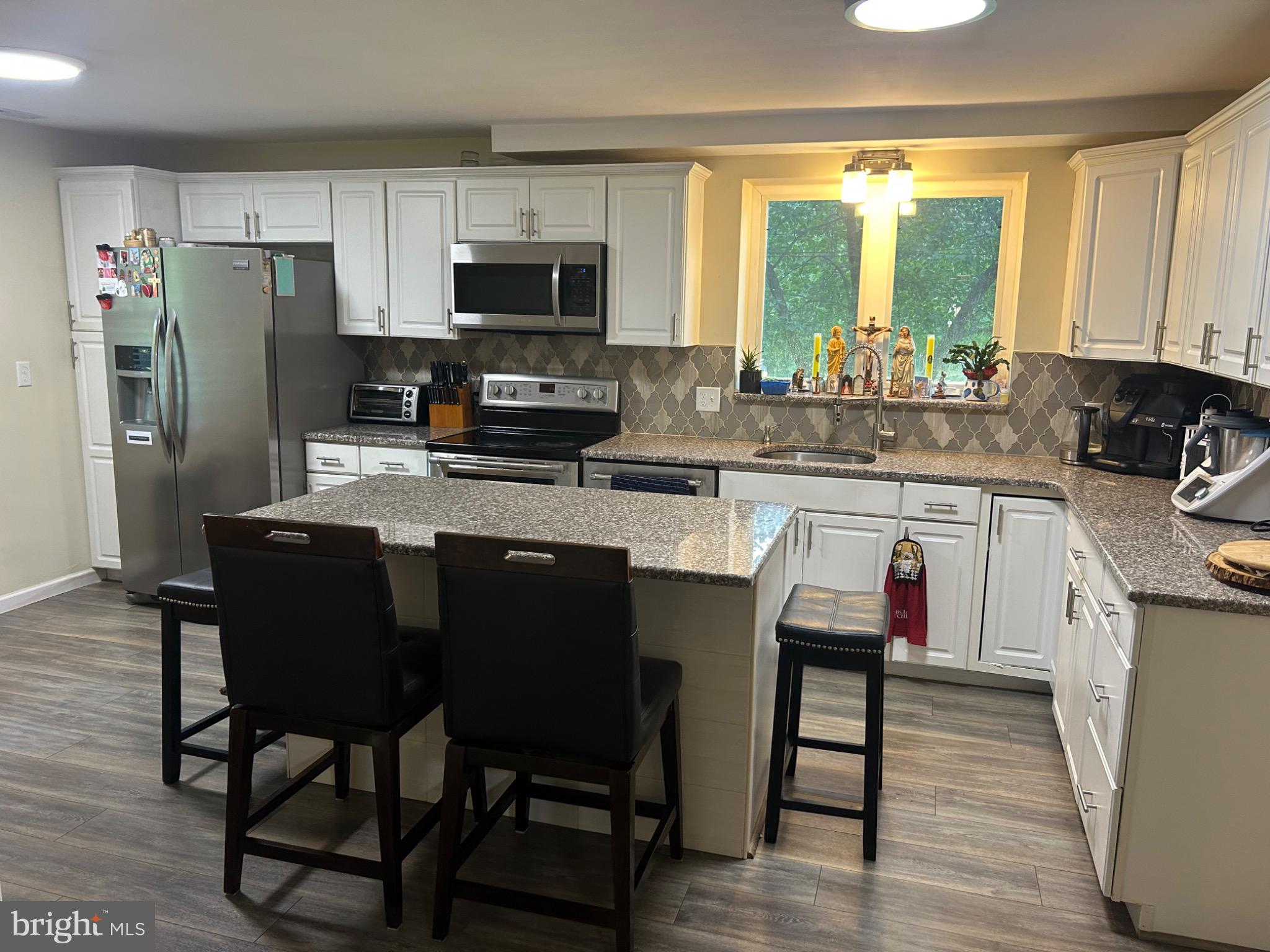 159 Planebrook Road Malvern, PA 19355 - Photo 11 of 30 a kitchen with stainless steel appliances granite countertop a table chairs microwave and sink