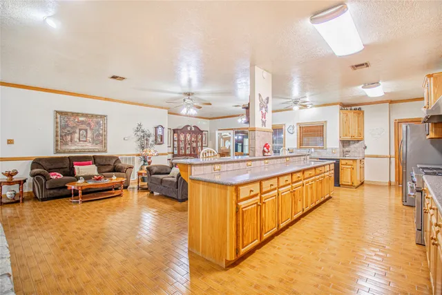 a large kitchen with stainless steel appliances granite countertop a stove and cabinets