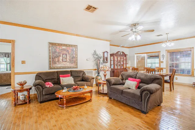a dining room with furniture a chandelier and wooden floor