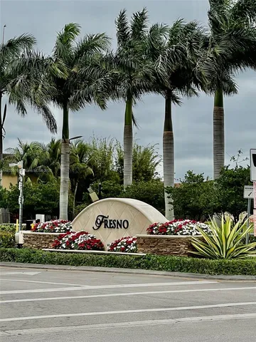 a front view of a house with a garden and palm trees