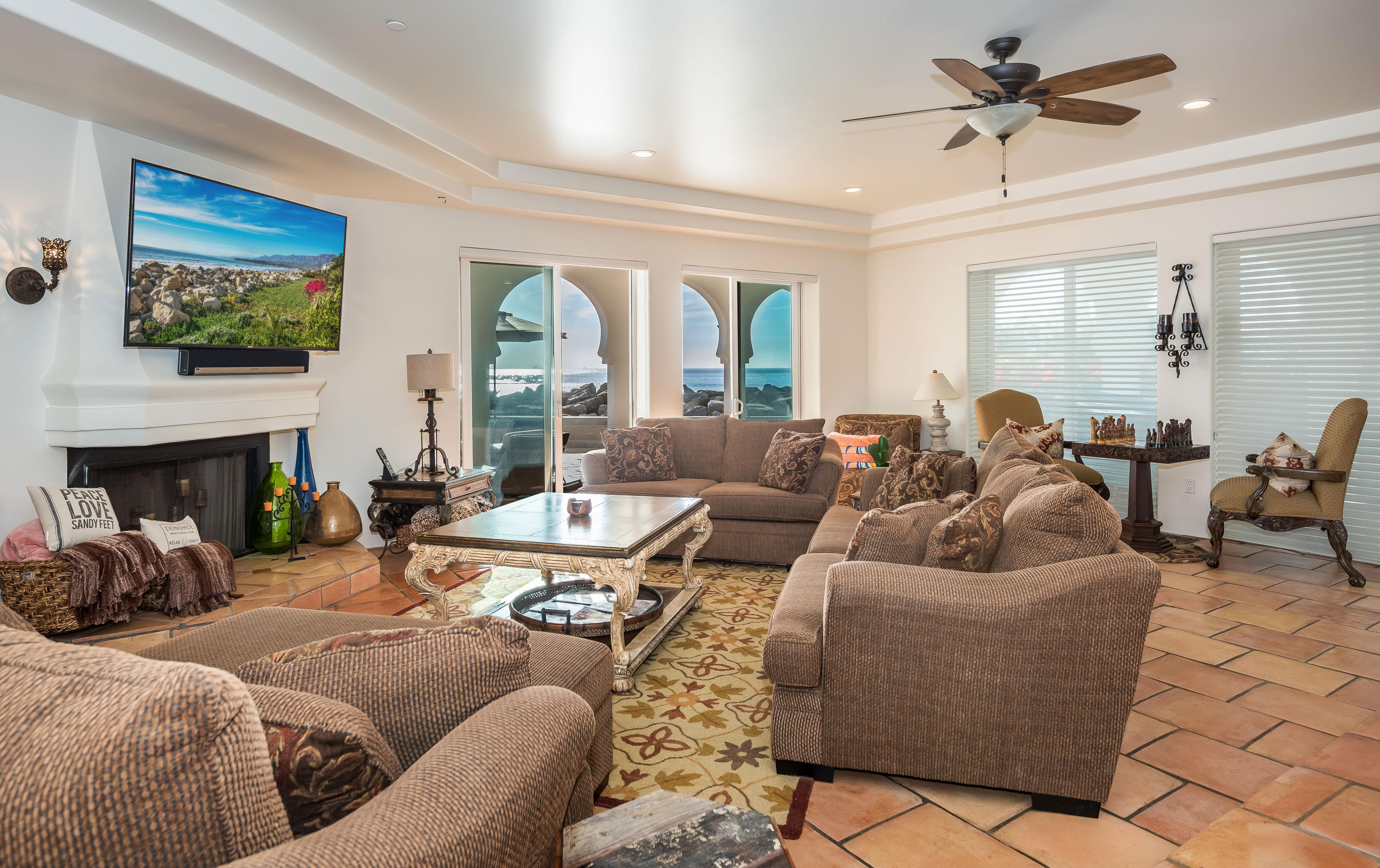 875 Sand Point Road Carpinteria, CA 93013 - Photo 5 of 25 a living room with furniture a large window and a fireplace