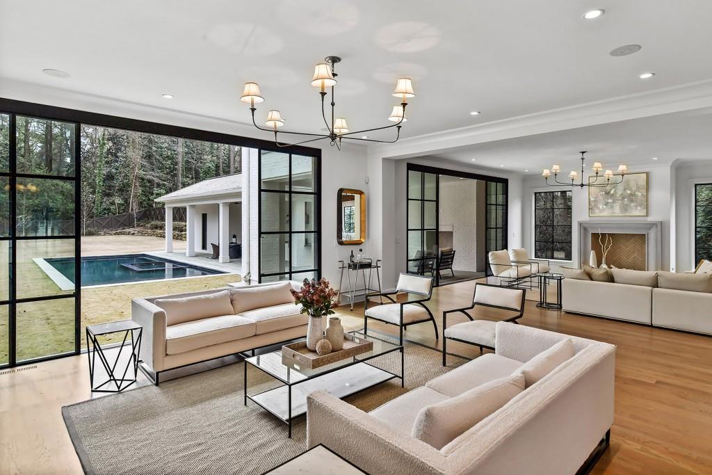258 Pineland Road Northwest Atlanta, GA 30342 - Photo 27 of 87 a living room with furniture a large window and a chandelier