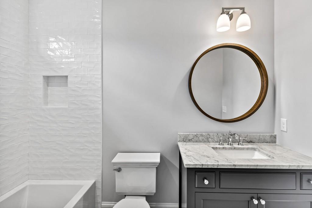 258 Pineland Road Northwest Atlanta, GA 30342 - Photo 65 of 87 a bathroom with a granite countertop toilet a sink and a mirror