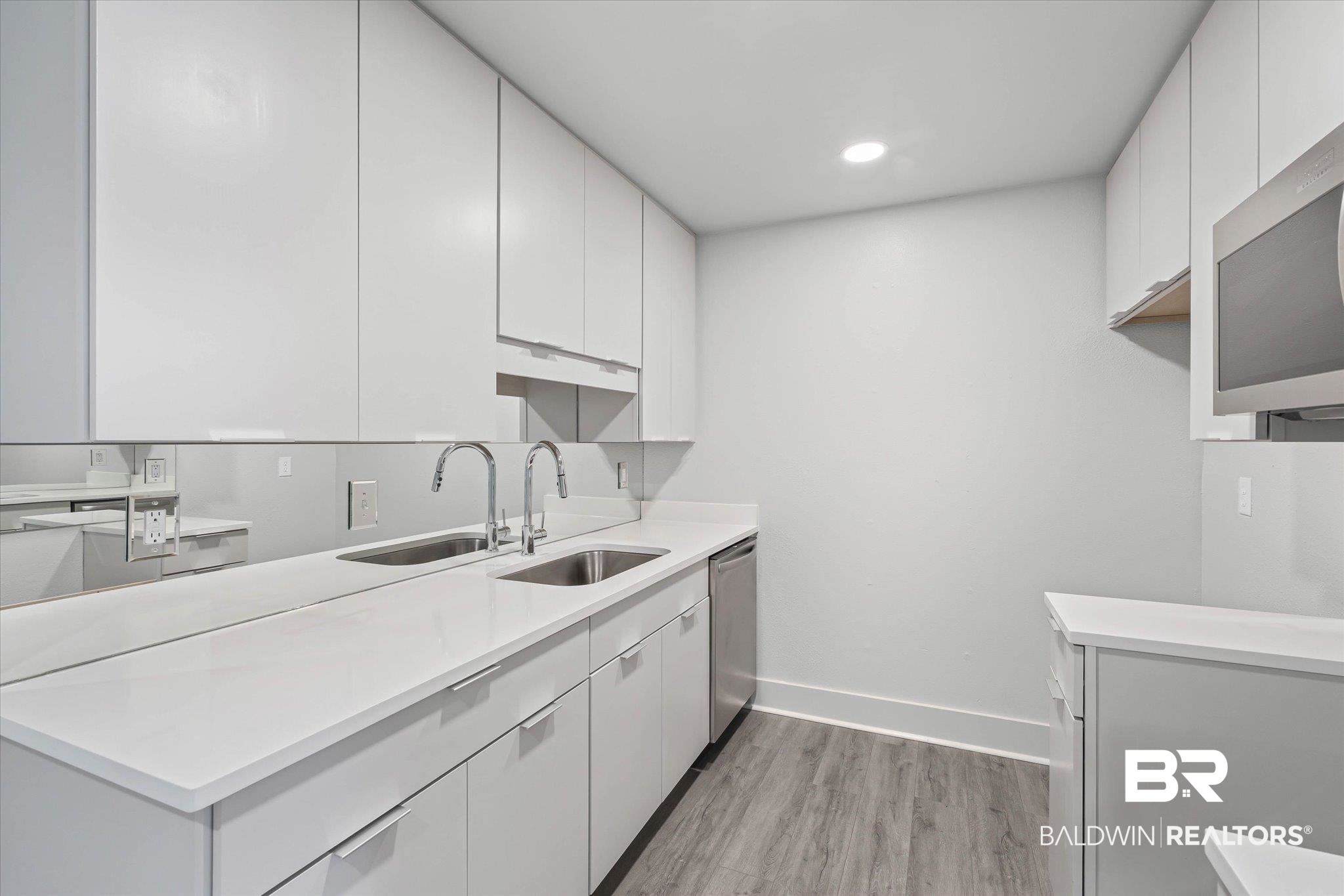 3655 Old Shell Road, Unit 712 Mobile, AL 36608 - Photo 6 of 19 Kitchen with white cabinetry, modern cabinets, light wood-style flooring, stainless steel appliances, and light stone counters