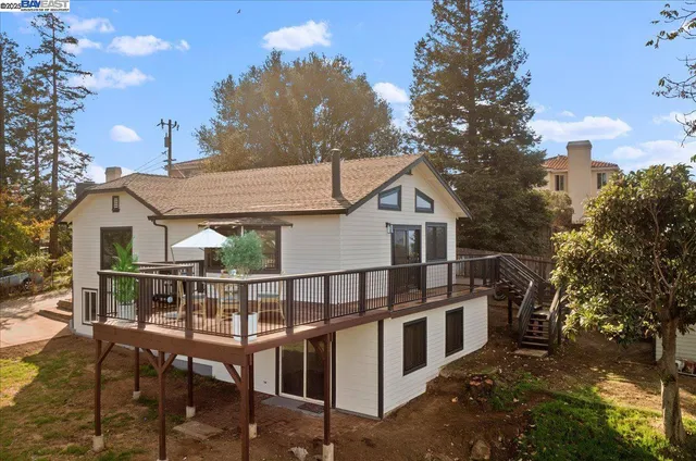 a view of house with a yard and balcony
