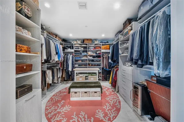 a view of walk in closet with clothes and shoes