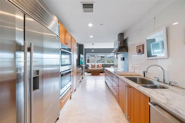 a kitchen with stainless steel appliances granite countertop a sink and a refrigerator