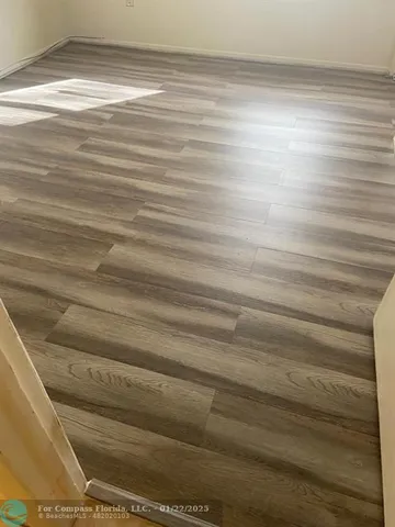 a view of a livingroom with an empty space and a kitchen