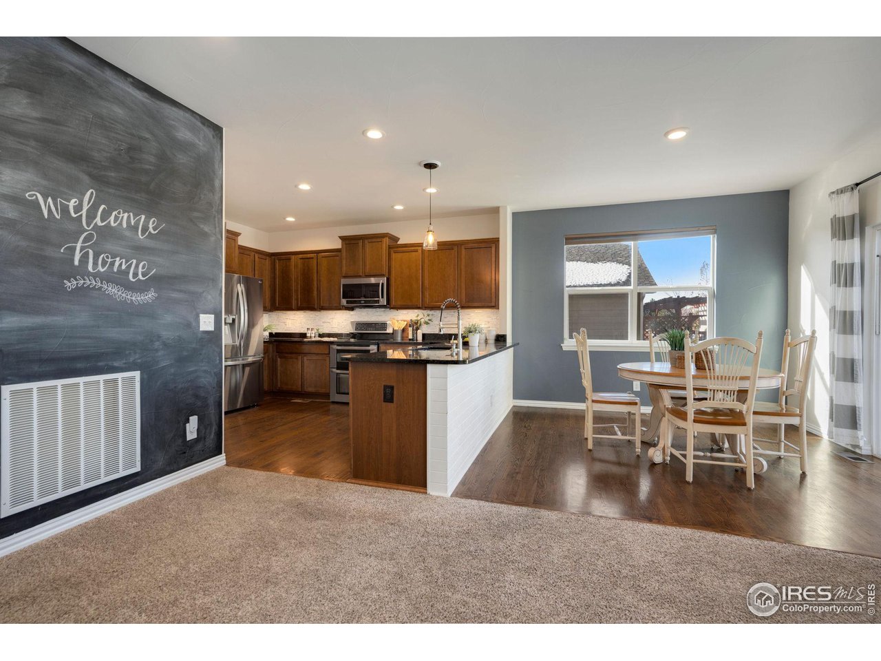 1540 Millfleet Drive Windsor, CO 80550 - Photo 12 of 40 a kitchen with stainless steel appliances granite countertop a stove top oven a sink a dining table and chairs