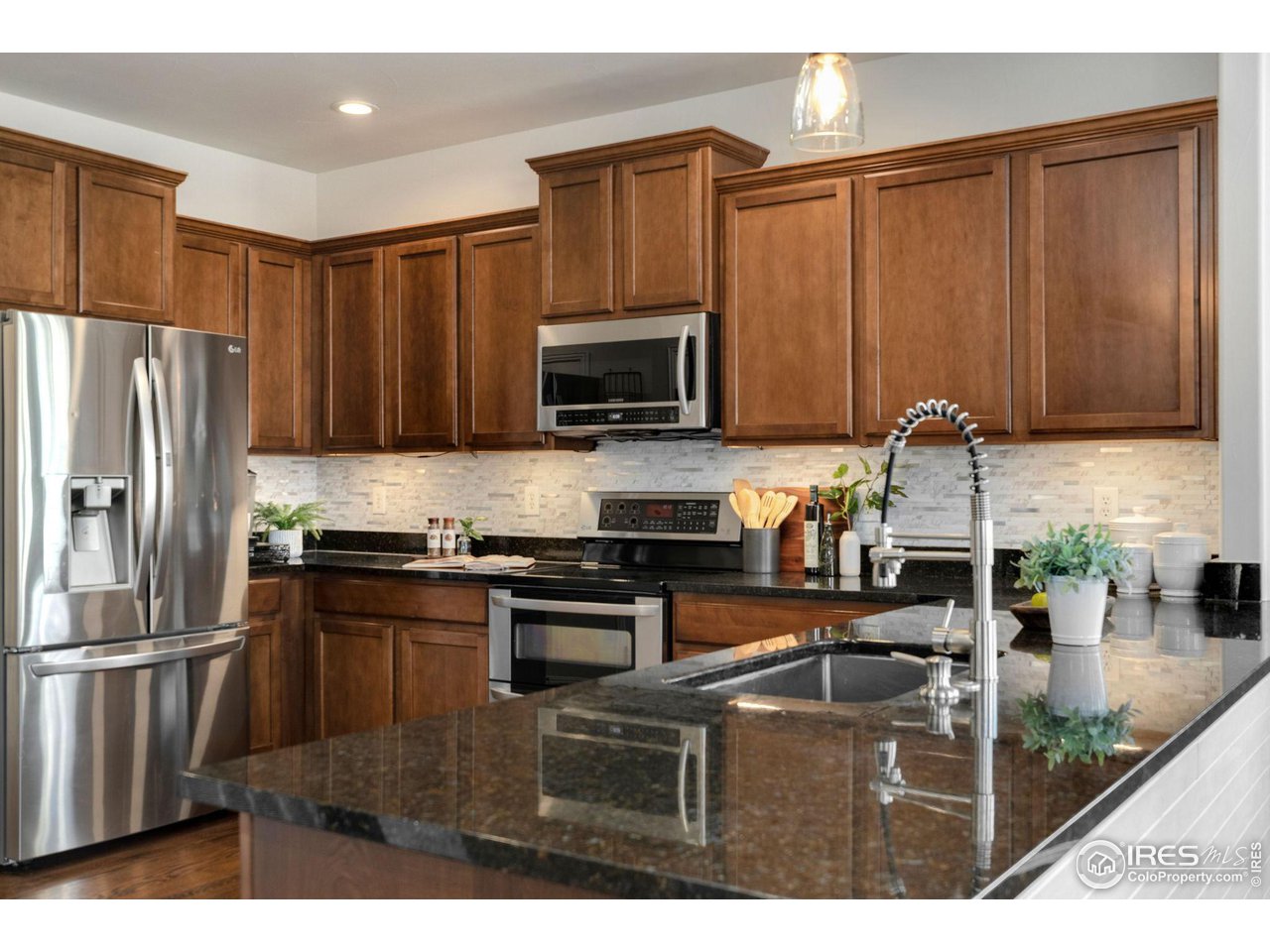 1540 Millfleet Drive Windsor, CO 80550 - Photo 14 of 40 a kitchen with stainless steel appliances granite countertop a stove a refrigerator a sink and dishwasher