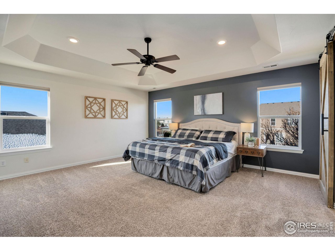 1540 Millfleet Drive Windsor, CO 80550 - Photo 20 of 40 a bedroom with a large bed and a chandelier