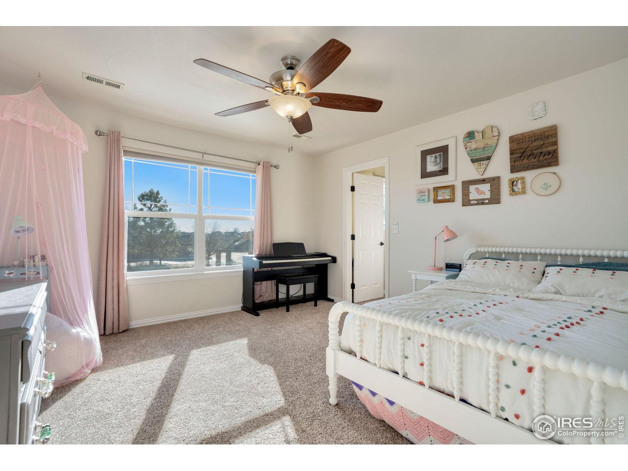 1540 Millfleet Drive Windsor, CO 80550 - Photo 31 of 40 a bedroom with a bed and a chandelier