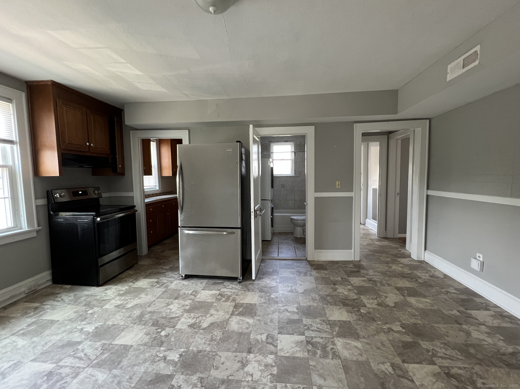 a kitchen with granite countertop a refrigerator and a sink