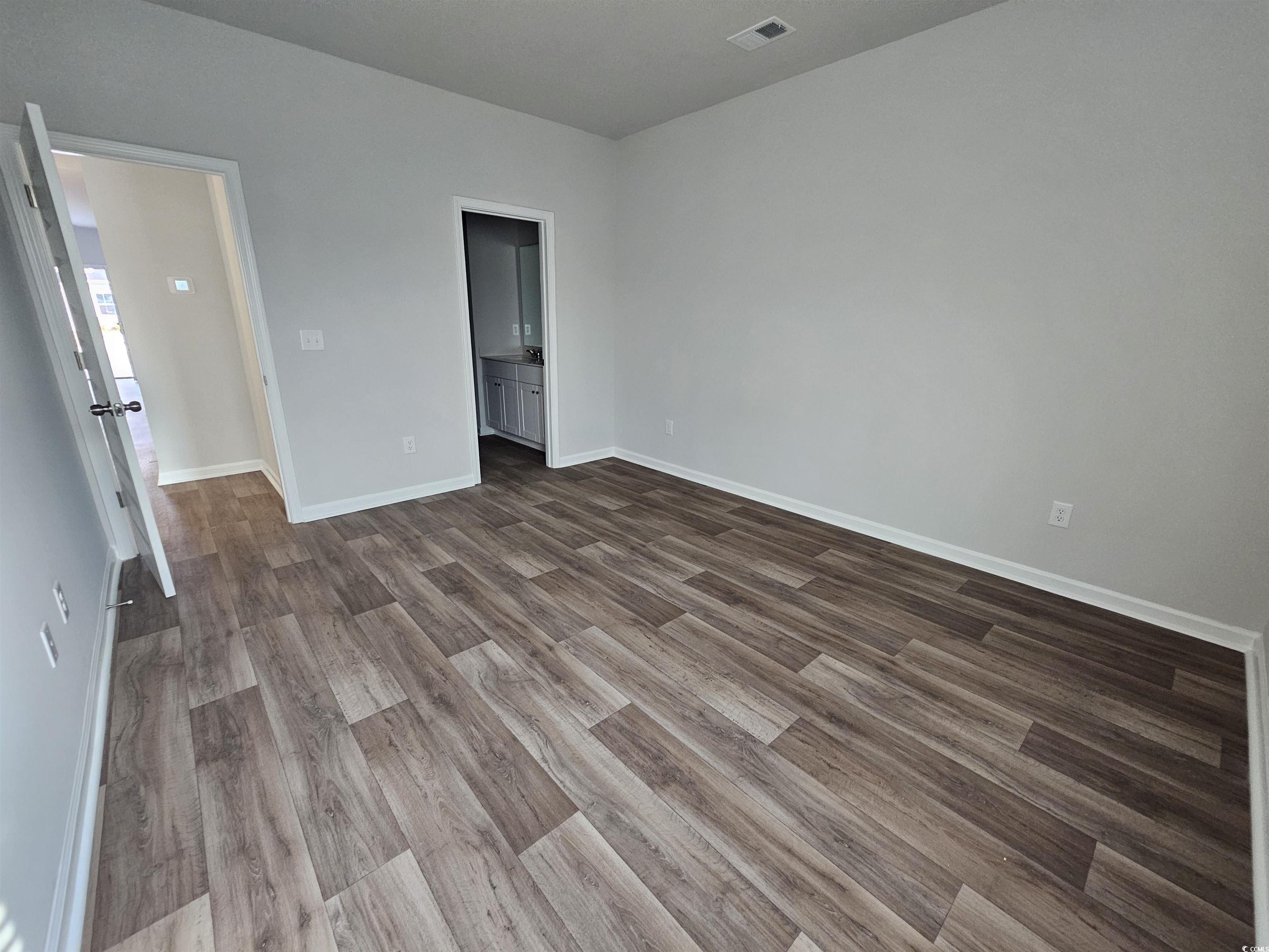 2096 Wild Indigo Circle Calabash, NC 28467 - Photo 10 of 29 Unfurnished bedroom with ensuite bathroom and light wood finished floors