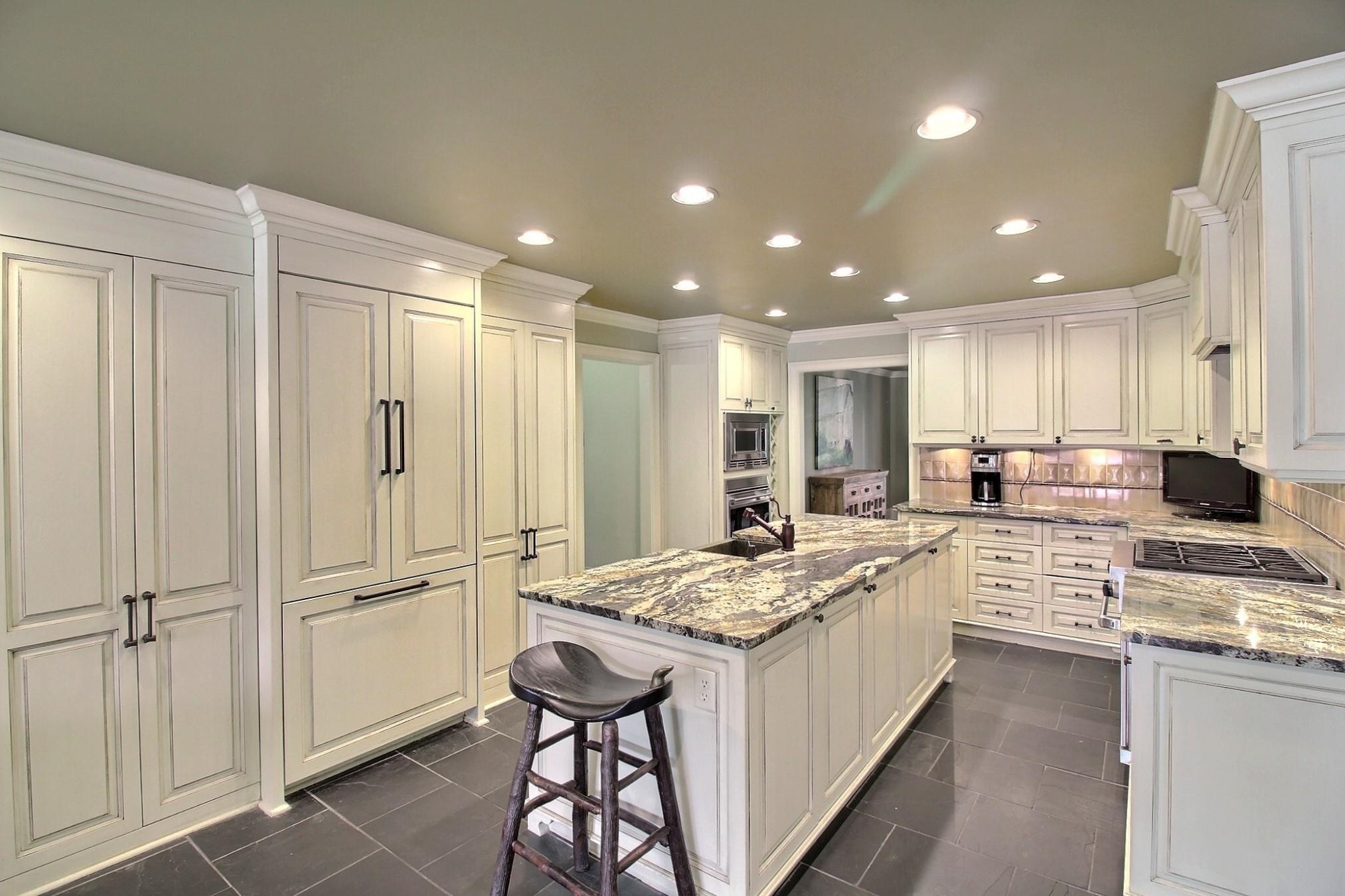 596 Bray Station Road Collierville, TN 38017 - Photo 12 of 36 Has cabinet-front refrigerator, loads of cabinets, granite tops, gas Wolf range, built-in oven, microwave, and slate flooring.