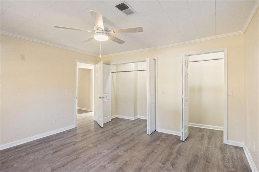 614 Burnett Ferry Road Southwest Rome, GA 30165 - Photo 11 of 29 an empty room with wooden floor fan and windows