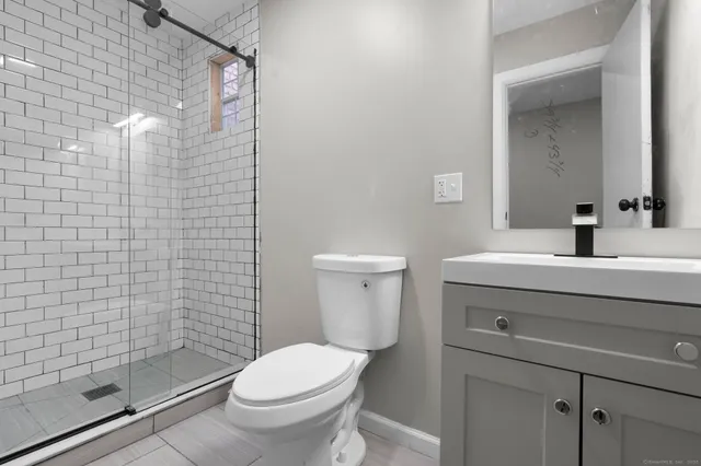 a bathroom with a sink a toilet and shower