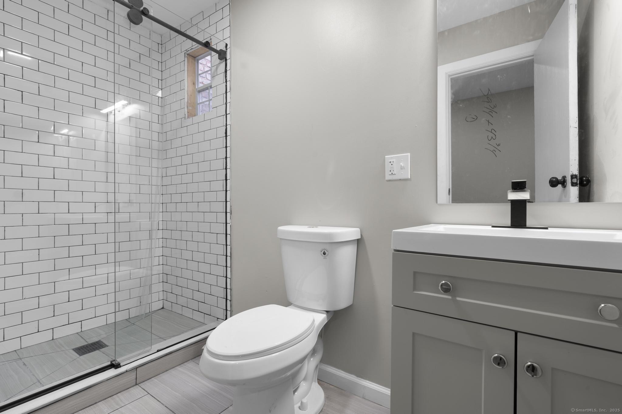 140 Grand Street, Unit 4C Waterbury, CT 06702 - Photo 13 of 14 a bathroom with a sink a toilet and shower