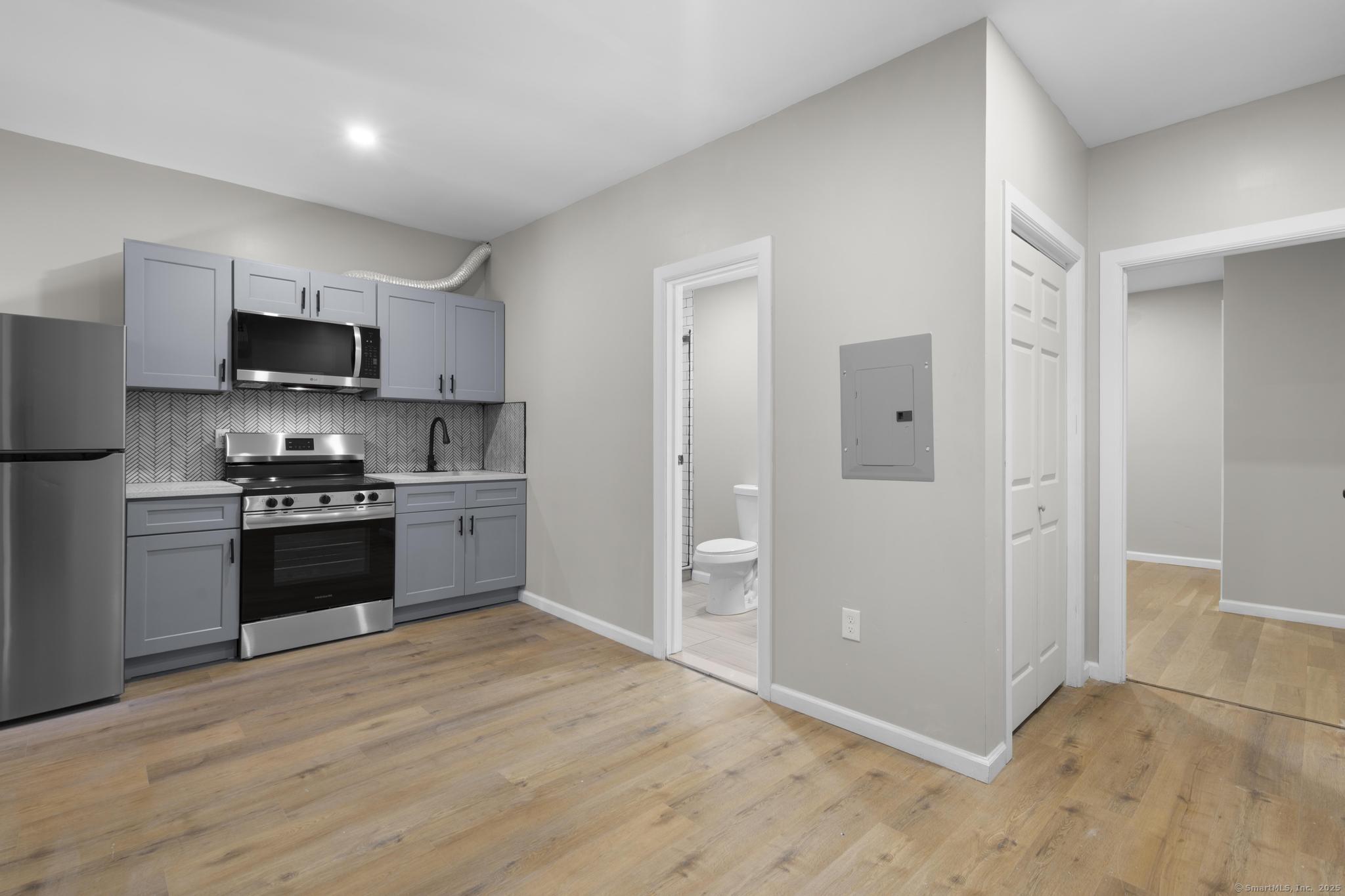 140 Grand Street, Unit 4C Waterbury, CT 06702 - Photo 6 of 14 a kitchen with granite countertop a refrigerator and a stove top oven