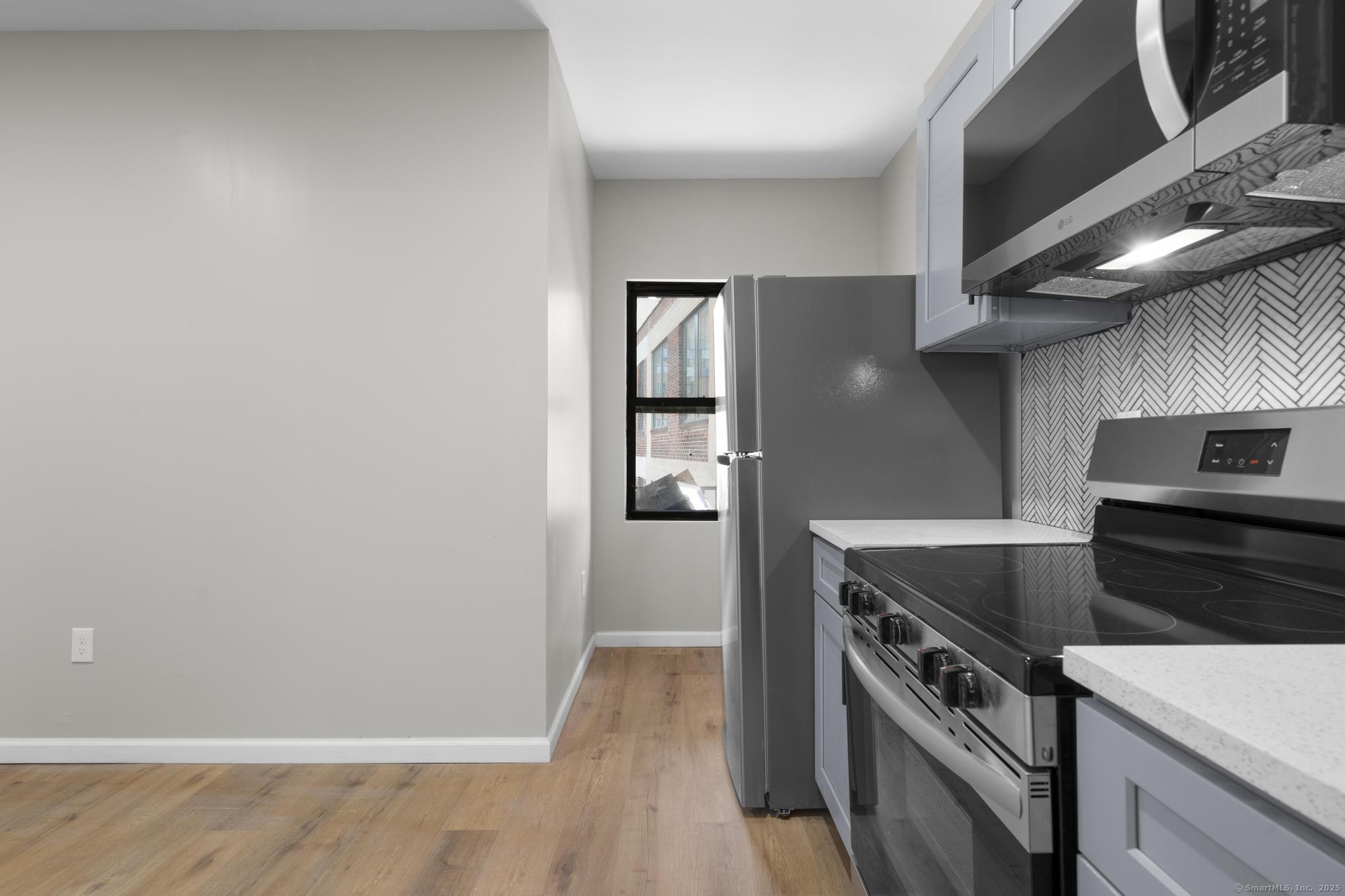 140 Grand Street, Unit 4C Waterbury, CT 06702 - Photo 8 of 14 a kitchen with a stove and a refrigerator