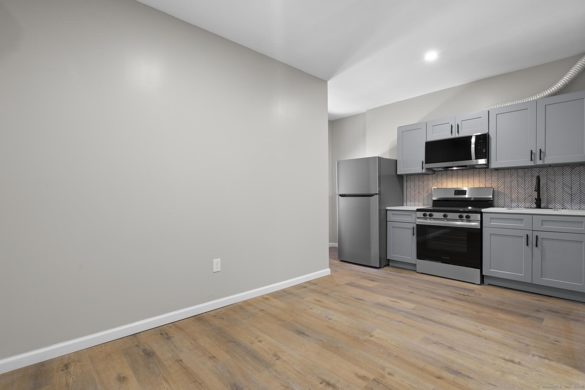 140 Grand Street, Unit 4C Waterbury, CT 06702 - Photo 9 of 14 a kitchen with a refrigerator and a stove top oven