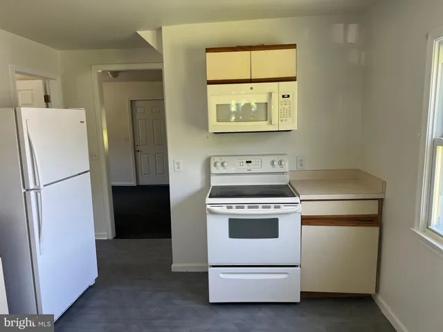a kitchen with a stove a refrigerator and a window