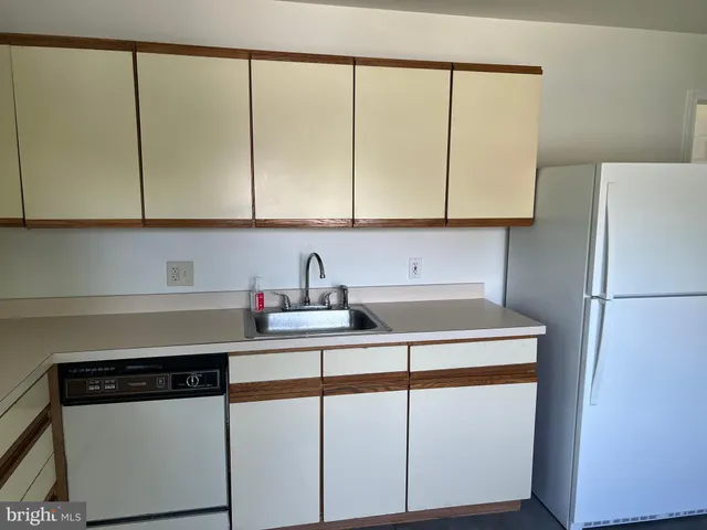 a kitchen with stainless steel appliances a sink a stove and a refrigerator with wooden floor