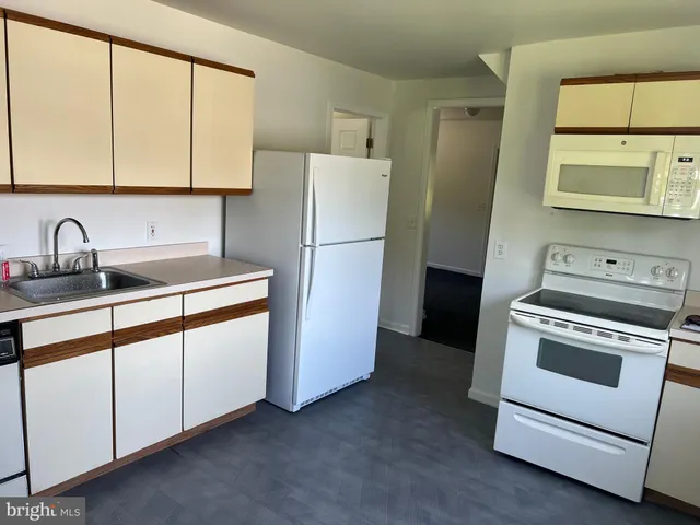 a kitchen with a refrigerator sink and cabinets