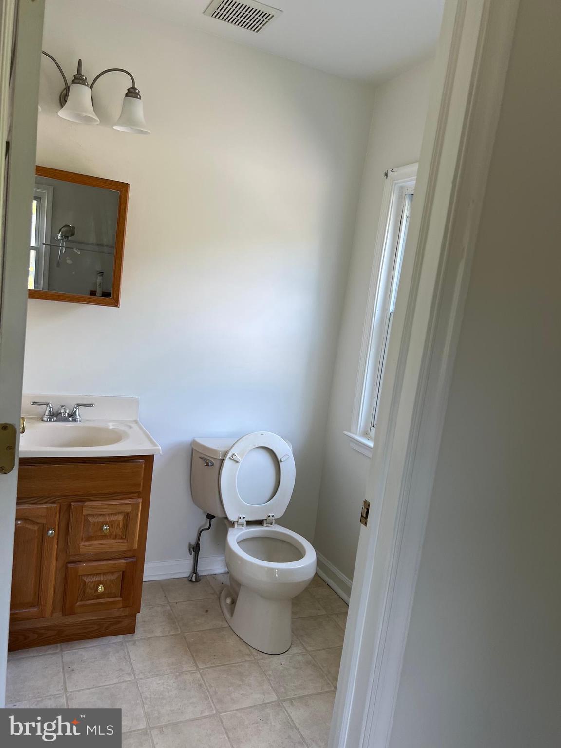 1636 Otts Chapel Road Newark, DE 19702 - Photo 8 of 24 a bathroom with a toilet a sink and mirror