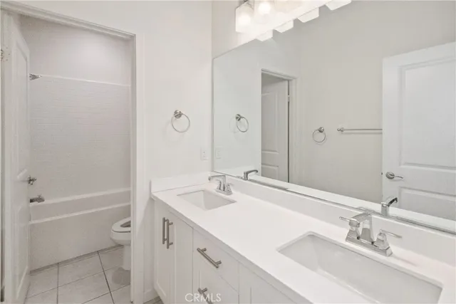 a bathroom with a granite countertop sink a toilet and shower