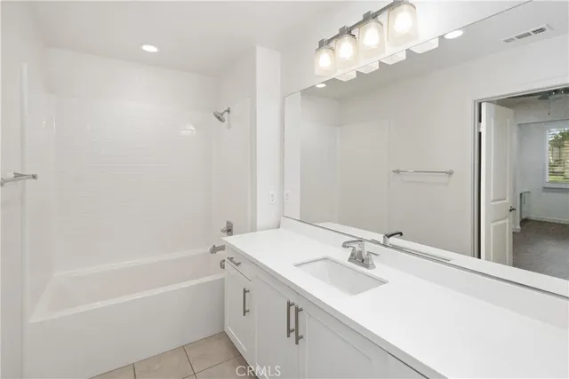 a bathroom with a tub a sink and mirror