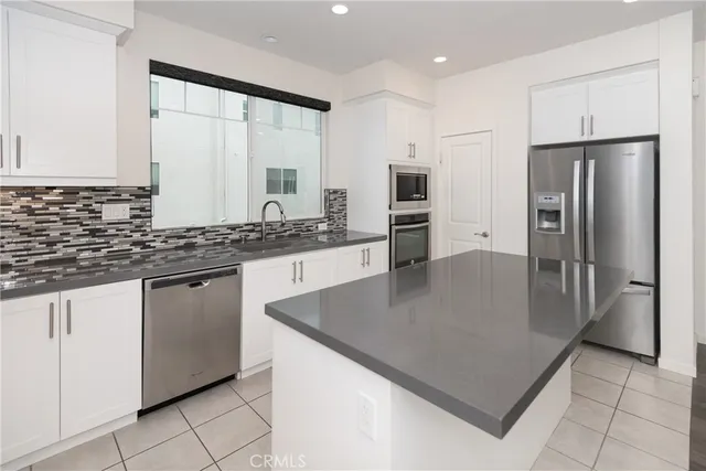 a kitchen with stainless steel appliances a refrigerator sink and microwave