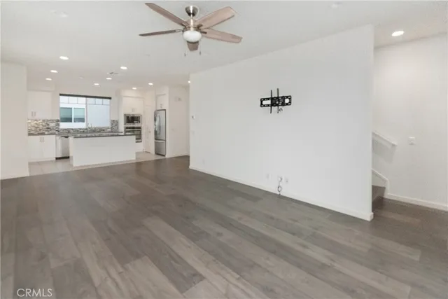 a view of a kitchen with wooden floor and a ceiling fan