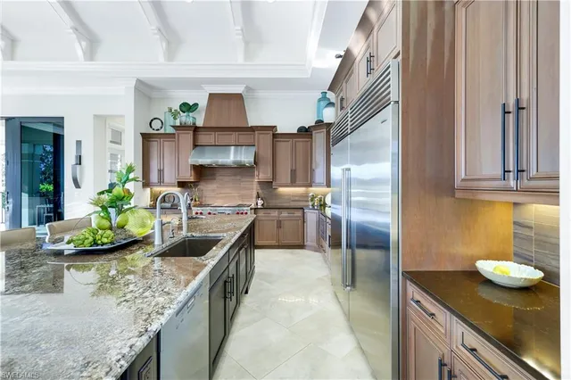 a kitchen with stainless steel appliances granite countertop a sink a stove and a refrigerator