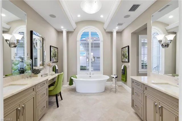 a spacious bathroom with a tub a double vanity sink and a large mirror