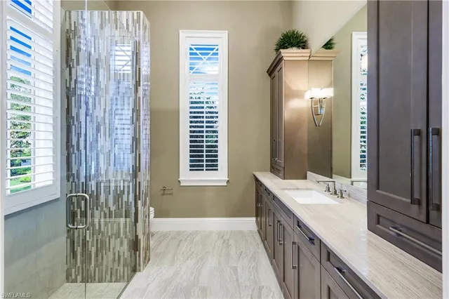 a bathroom with a granite countertop sink a mirror and a picture on the wall